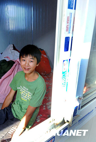 6月5日，四川省青川县回龙村的李春成小朋友坐在由浙江省援建的活动板房里。 新华社记者 谢环驰 摄